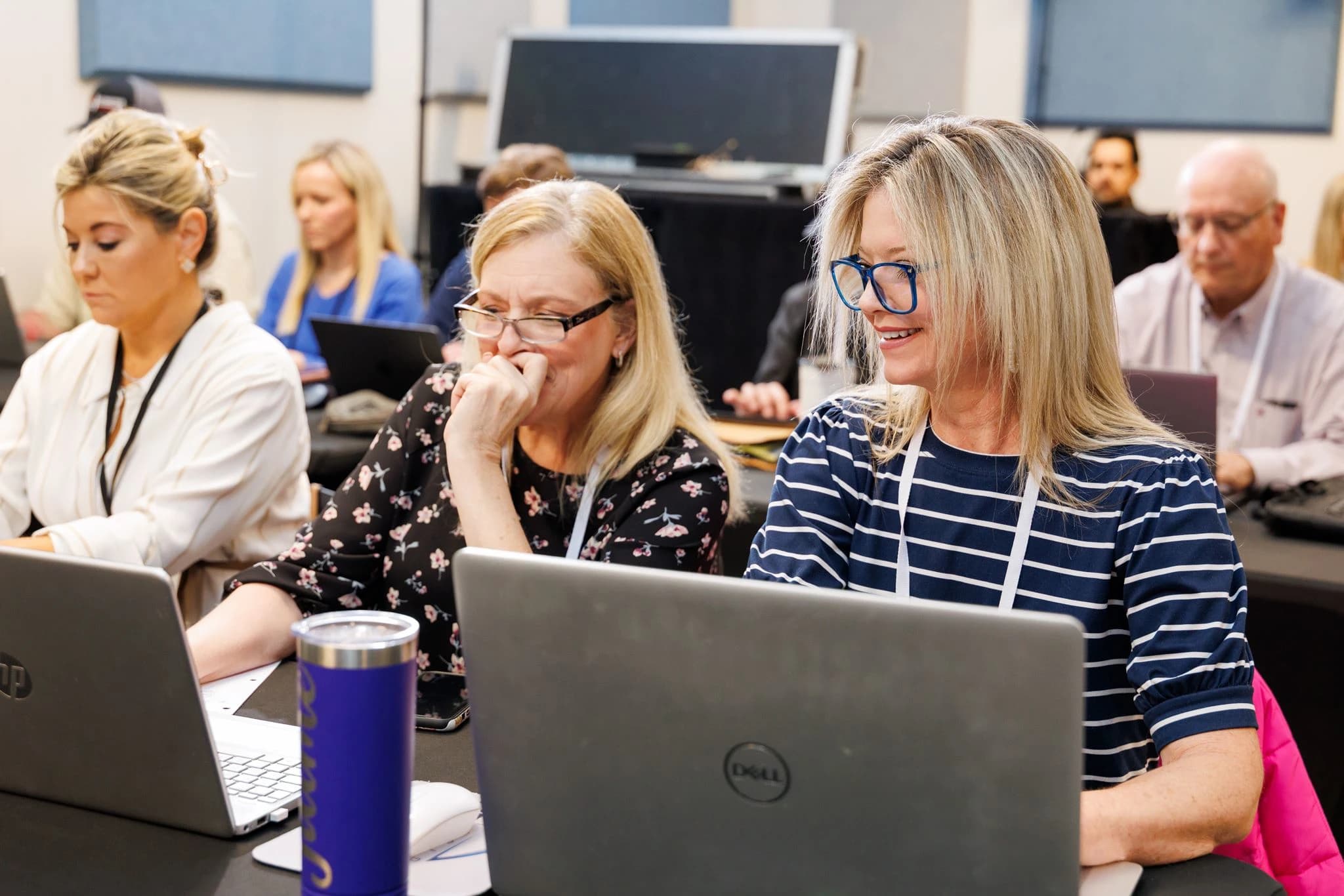 Participants use laptops during an OpenAI Academy training session.